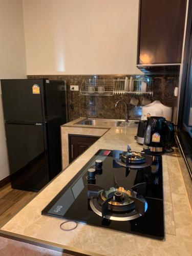 a kitchen with a black refrigerator and a counter top at Smile Home Krabi Klong Moung Beach in Klong Muang Beach