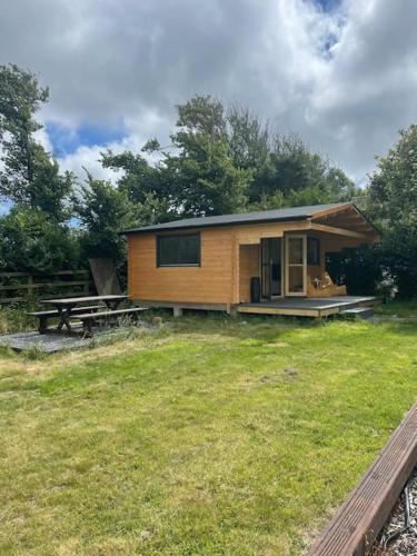 a small cabin with a picnic table in a yard at The Gallows in Pembroke