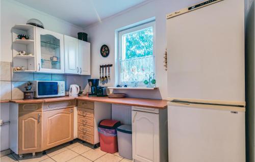 a kitchen with white cabinets and a refrigerator at 8 Bedroom Beautiful Home In Miastko in Starzno