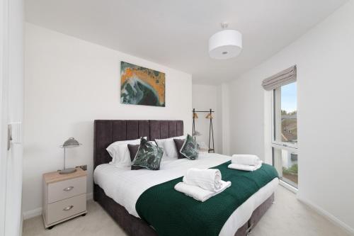 a bedroom with a bed with towels on it at Town Center 2 bed Serviced Apartment 08 with parking, Surbiton By 360Stays in Surbiton