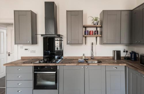 a kitchen with gray cabinets and a counter top at Rock Pool Reach - central location with parking in Broadstairs