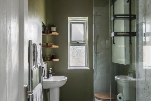 Un baño con lavabo, inodoro y ventana. en Rock Pool Reach - central location with parking, en Broadstairs