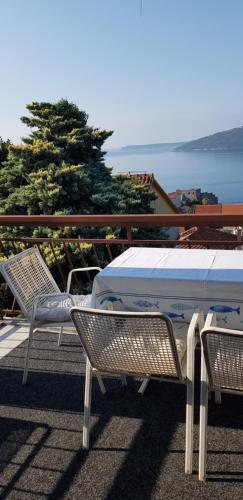 a table and chairs on a balcony with a view of the ocean at Guest House Cinderella in Herceg-Novi
