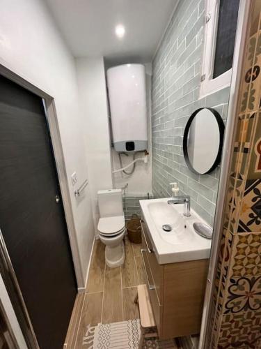 une salle de bain avec toilettes, lavabo et miroir dans l'établissement Superbe appartement au coeur du Mourillon refais à neuf proche des plage, à Toulon