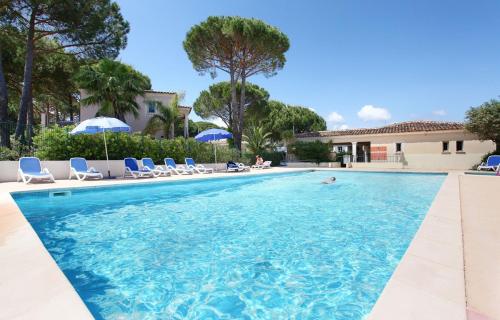 una piscina con sedie e ombrelloni di CASA RAMA ST Tropez a Saint-Tropez