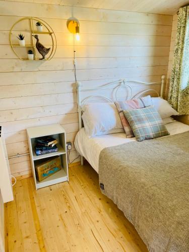 a bedroom with a bed and a night stand next to it at The Gallows in Pembroke