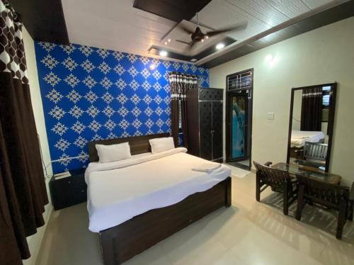 a bedroom with a bed and a blue wall at Farm Green View Resort in Orchha