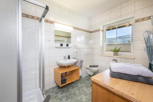 a bathroom with a sink and a toilet and a shower at Aparthotel Stadler in Flachau