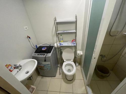 La petite salle de bains est pourvue de toilettes et d'un lavabo. dans l'établissement Trees Residences Fairview, à Manille