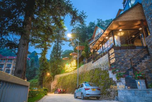 a car parked in a parking lot in front of a building at Sapa Pine Hill Eco Lodge in Sa Pa