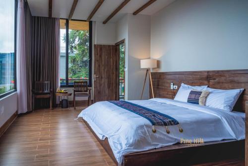 1 dormitorio con 1 cama grande y cabecero de madera en Sapa Pine Hill Eco Lodge, en Sa Pa