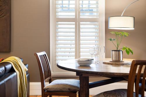 a dining room with a table and chairs and a window at Maple - quaint cottage with fireplace and spa in Daylesford