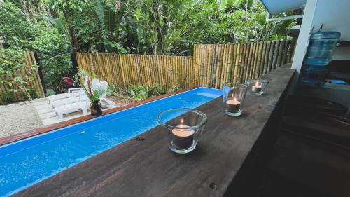 a table with candles on it next to a swimming pool at Brand new huge apt with Air Conditioner and a private pool and kitchen in Cocles