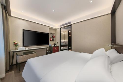 a hotel room with a bed and a flat screen tv at Hotel Fu Shang in Guangzhou
