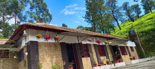 uma casa com uma colina verde ao fundo em Munnar Home Stay em Munnar