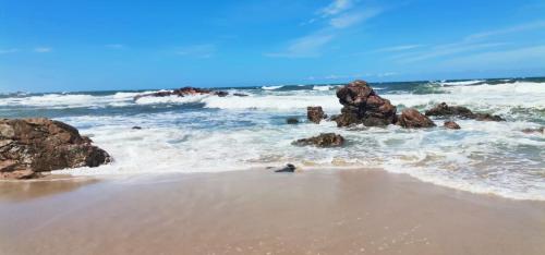 una playa con rocas en el agua y el océano en Grace Manor, en Port Edward