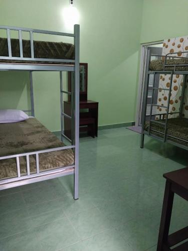 a room with two bunk beds and a desk at Omah 365 Homestay in Sentool
