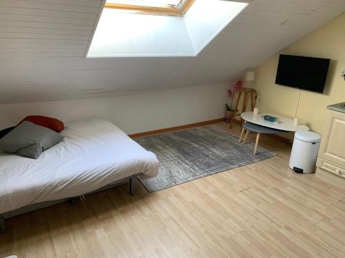 リスルにあるSTUDIO SPACIEUX remis a neuf Sur Pistesのベッドルーム1室(ベッド1台、テーブル、天窓付)