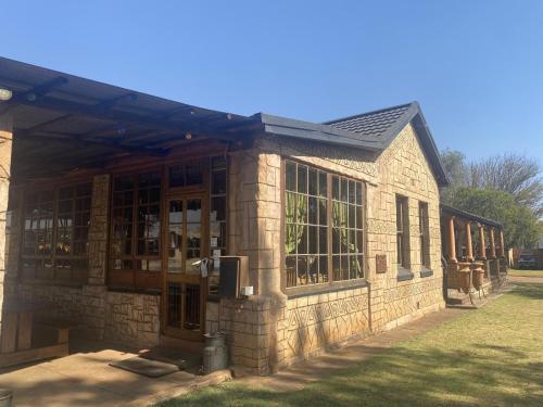 a large stone building with glass doors and windows at Eastwoods Lodge in Springs