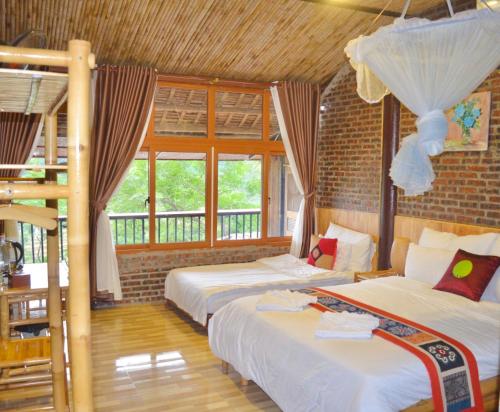 a bedroom with two beds and a balcony at Inh La Home Pu Luong in Pu Luong