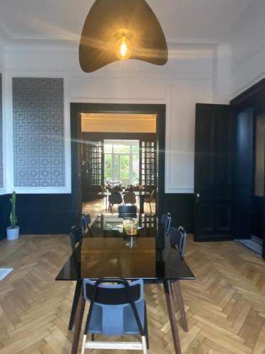 a dining table and chairs in a living room at Maison Mimerel Colodge in Roubaix