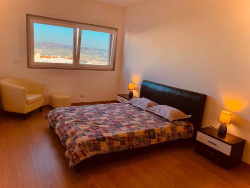 a bedroom with a bed and a window and a chair at Apartamento ALTAMIRA T2 SERRA SHOPPING in Covilhã