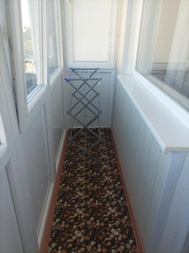 a small room with a pebble floor and two windows at Centrinio parko apartamentai in Šiauliai