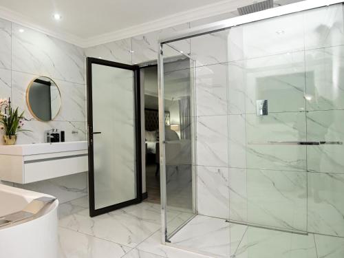a bathroom with a glass shower and a sink at Sou House in Louis Trichardt