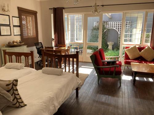 a living room with two beds and a table and chairs at Home From Home, Waverley B&B, Johannesburg in Johannesburg