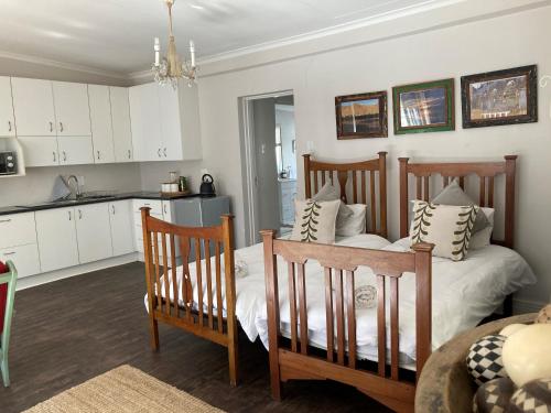a bedroom with two beds and a kitchen at Home From Home, Waverley B&B, Johannesburg in Johannesburg