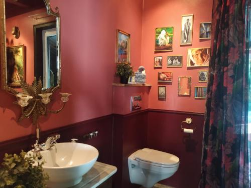 克里斯蒂安桑的住宿－Villa Villekulla，红色的浴室设有卫生间和水槽