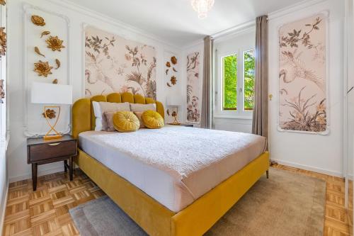 a bedroom with a large bed with yellow pillows at Soft Glam 1-bedroom appt - Lake & Mountain View in Territet