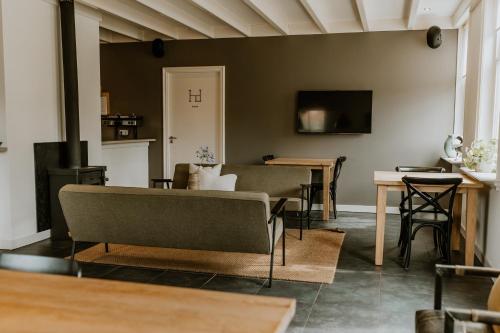 een woonkamer met een bank en een tafel bij Vakantiewoning De Beiert in Delden