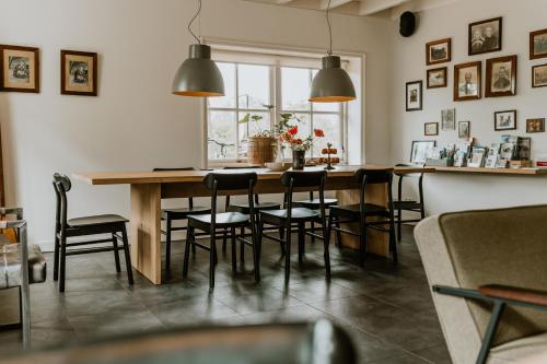 een eetkamer met een houten tafel en stoelen bij Vakantiewoning De Beiert in Delden