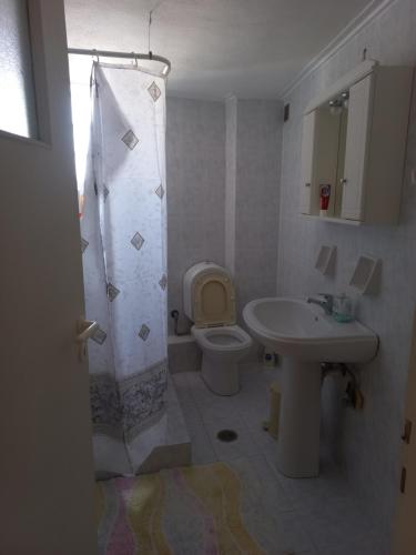 ein Badezimmer mit Toilette und Waschbecken in der Unterkunft Great apartment with parking in the city center in Tripolis