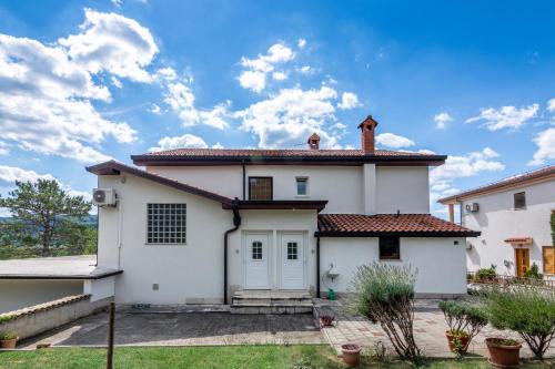 a white house with a roof at Apartments with a parking space Buzet, Central Istria - Sredisnja Istra - 17562 in Buzet