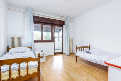 een slaapkamer met 2 bedden en een raam bij Apartment Buzet 17562a in Buzet