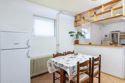a kitchen with a table and a refrigerator at Apartment Buzet 17562a in Buzet