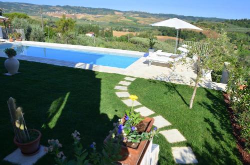 a backyard with a swimming pool and a garden at Casa Magnolia in Terricciola