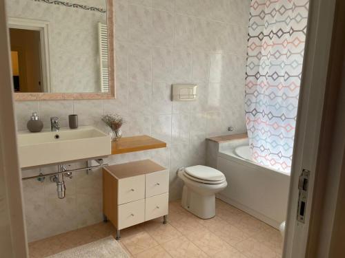 a bathroom with a sink and a toilet and a bath tub at Parvis home in Brindisi