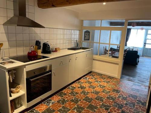eine Küche mit weißen Schränken und Fliesenboden in der Unterkunft House Number 2 in Mirepoix
