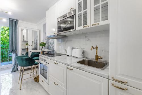 a kitchen with white cabinets and a sink at L'Eden studio with a balcony - Lake View in Montreux