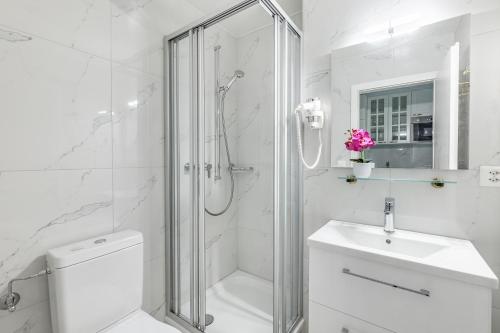 ein weißes Bad mit einer Dusche, einem WC und einem Waschbecken in der Unterkunft L'Eden studio with a balcony - Lake View in Montreux