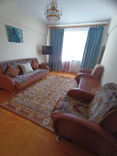 a living room with couches and a rug at Квартира на Абая in Almaty