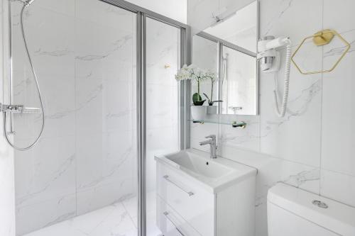 a white bathroom with a sink and a shower at Bon Port 1-bedroom apartment – Lakefront in Territet