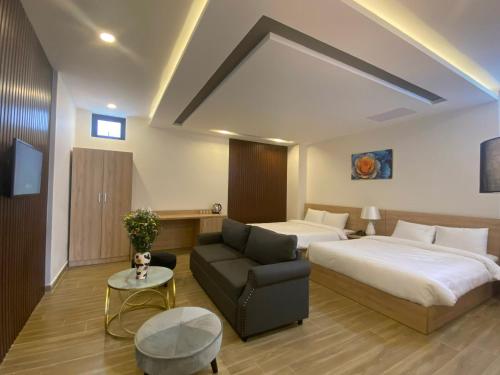 une chambre d'hôtel avec un lit et un canapé dans l'établissement Q's House Dalat, à Đà Lạt