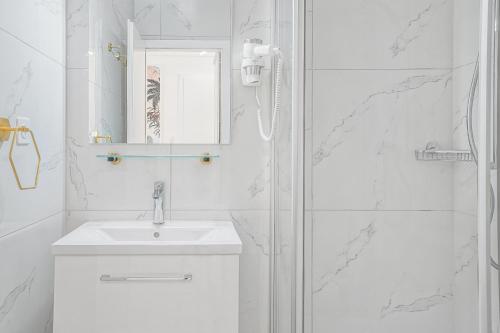 a white bathroom with a sink and a shower at Tropical studio with a balcony - Lake View in Montreux