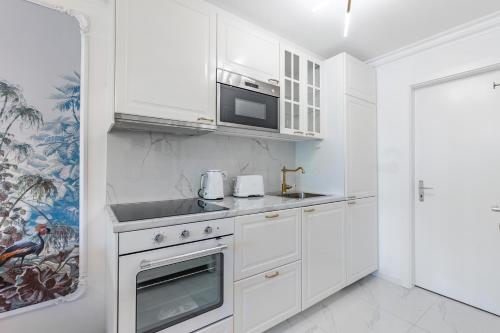 a white kitchen with a sink and a microwave at Secret Garden studio – Lakefront in Montreux