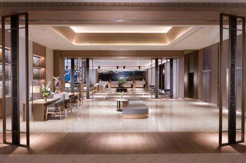 a lobby of a hotel with tables and chairs at Hilton Hiroshima in Hiroshima