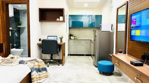 a room with a bed and a desk and a tv at ZEN Studios - DLF CyberCity Gurgaon in Gurgaon